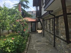 an alleyway leading to a building with flowers at Guest House Katya in Nesebar