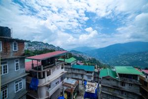 a group of buildings with mountains in the background at Citrus Boutique Hotel in Gangtok