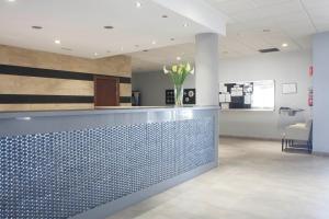 a lobby with a blue tile counter with a vase of flowers at VALHOTEL Residencia Tiempo Libre El Puig in El Puig