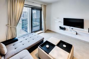 a living room with a couch and a large window at Sparkle Tower, Dubai Marina in Dubai