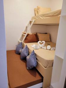 ein kleines Schlafzimmer mit einem Etagenbett mit blauen Kissen in der Unterkunft Fame Residences Tower-1 Unit 3207 in Mandaluyong 1 Br w Balcony City view in Manila