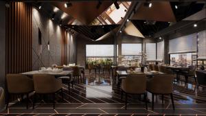 a restaurant with tables and chairs and windows at Hotel Nalanda in Ahmedabad