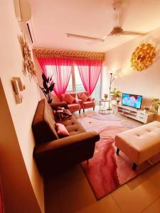 a living room with a couch and a tv at Sentrovue B Pink House in Bandar Puncak Alam