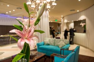 a pink flower in a room with a blue couch at Howard Johnson Plaza by Wyndham Buenos Aires Florida Street in Buenos Aires