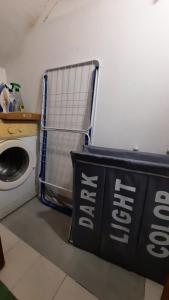een wasruimte met een wasmachine en een bord bij COZYHOME in Catania
