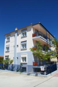 a white building with a fence in front of it at Thalassenia Studios in Hanioti