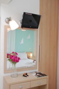 a mirror with a tv on top of a bedroom at Thalassenia Studios in Hanioti
