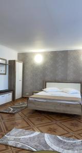 ein Schlafzimmer mit einem großen Bett und Holzboden in der Unterkunft Dany Holiday in Eforie Nord