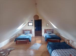 a attic room with three beds and a staircase at Babou Maramures in Breb