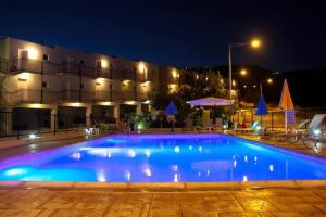 a large swimming pool in front of a building at night at Panoramic Holidays - Deluxe 1 in Peyia
