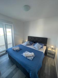 ein Schlafzimmer mit einem Bett mit einer blauen Bettdecke in der Unterkunft Villa Iva Vodice in Vodice