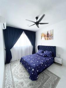 a bedroom with a blue bed and a ceiling fan at RS HOMESTAY BANDAR SERI ISKANDAR in Seri Iskandar