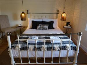 een slaapkamer met een bed met een wit bedframe bij The Green Man Boutique Hotel in Takeley