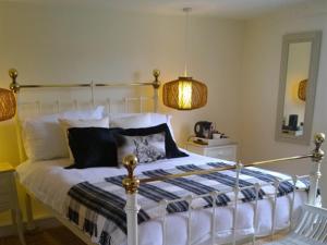 a bedroom with a bed and a lamp and a mirror at The Green Man Boutique Hotel in Takeley