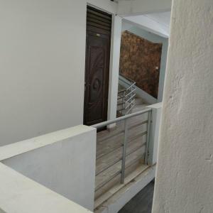 Una escalera con una puerta de madera en una casa en Mtwapa Pride Studio Apartment 33, en Mtwapa