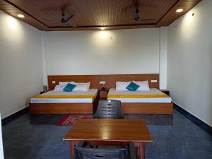 a room with two beds and a table and a desk at Maavaa Dreamland in Lansdowne