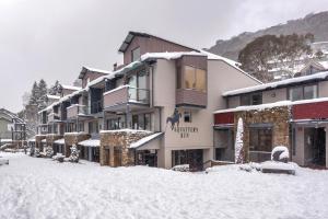a building with snow on the ground in front of it at Silver Run Thredbo in Thredbo
