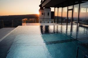 uma piscina no topo de um edifício com uma torre de relógio em Hotel Schachner em Maria Taferl