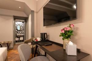 a living room with a table with flowers on it at Loly Boutique Hotel Roma in Rome