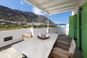 a table and chairs on a balcony with a view of the mountains at Villa Areto in Kamares