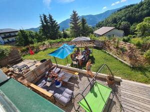 a group of people sitting around a swimming pool at Ferienhaus Kräuterhäusl in Puchenstuben