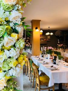 パルティニシュにあるPensiune Rara Paltinisのダイニングルーム(白と黄色の花のテーブル付)