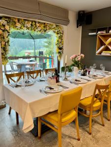 a dining room with a long table with yellow chairs at Pensiune Rara Paltinis in Păltiniş