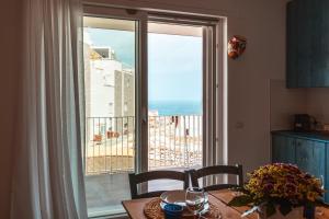 a kitchen with a table and a view of the ocean at Da Riva Apartment Sea View - Housea in Polignano a Mare