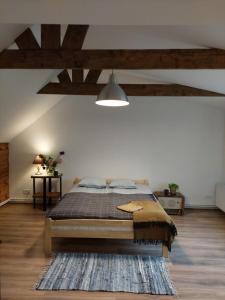 a bedroom with a bed and a ceiling with beams at Zvejnieka ligzda in Ventspils