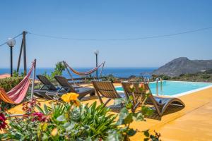 プラキアスにあるNew Modern Villa Mirthios Panorama with Private Swimming Pool and BBQ!のスイミングプールの横に座る椅子
