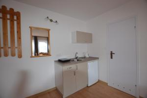 a white kitchen with a sink and a mirror at Dom Gościnny Przystań in Międzywodzie +91 photos