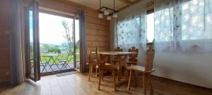 a dining room with a table and chairs and a window at NowiNowe Domki in Dzianisz