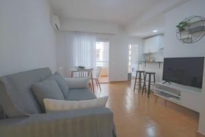 salon z kanapą i telewizorem z płaskim ekranem w obiekcie 062 - Club Náutico 005 - comfortHOLIDAYS w mieście Santa Pola