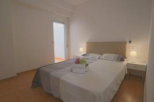 sypialnia z dużym białym łóżkiem i oknem w obiekcie 062 - Club Náutico 005 - comfortHOLIDAYS w mieście Santa Pola