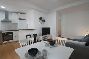 kuchnia i salon z białym stołem i krzesłami w obiekcie 062 - Club Náutico 005 - comfortHOLIDAYS w mieście Santa Pola