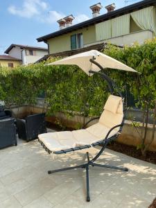einen Stuhl mit Sonnenschirm auf einer Terrasse in der Unterkunft Apartamento in Carpenedolo