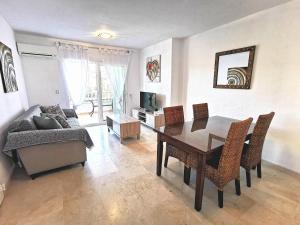 een woonkamer met een eettafel en een bank bij Nice apartment in a wonderful area in Villacosta