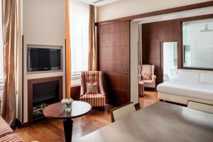 Habitación de hotel con cama y sala de estar. en Ricasoli Firenze Luxury Apartments | UNA Esperienze, en Florencia