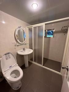 ein Bad mit einer Dusche, einem WC und einem Waschbecken in der Unterkunft Cingjing Four Seasons B&B in Renai