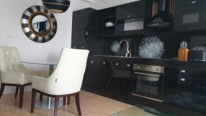 uma cozinha com armários pretos e uma mesa e cadeiras em Květinový apartmán A3B v Chomutově em Chomutov