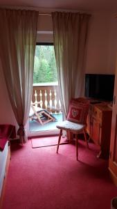 een woonkamer met een stoel en een raam bij Haus Guentli in Mittelberg