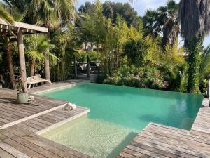 a swimming pool in a backyard with a wooden deck at Villa Bali in Cassis