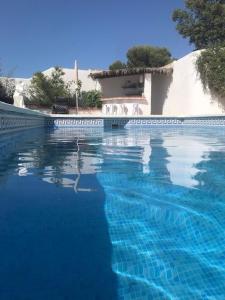 a swimming pool with blue water in front of a house at Todos Y Tonya in Archidona +74 photos