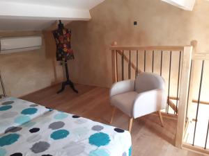 una camera con un letto e una sedia di Mazet des lavandes a Saint-Quentin-la-Poterie