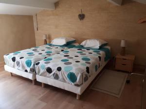 una camera con un letto e un piumone blu e bianco di Mazet des lavandes a Saint-Quentin-la-Poterie
