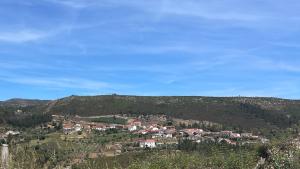 a group of houses on a hill in the distance at Vale Encantado - Alojamento Local in Mação