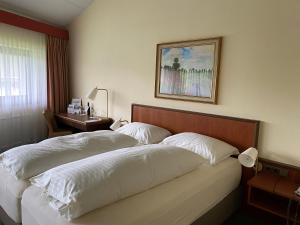 Bett in einem Hotelzimmer mit einem Bild an der Wand in der Unterkunft Landzeit Restaurant Angath in Angath