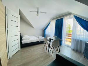 ヤスタルニャにあるWilla Przystańのベッドルーム1室(ベッド1台、テーブル、窓付)