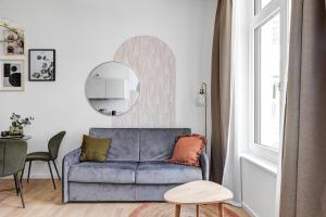 a living room with a blue couch and a mirror at Luxury Apartments in East Side Gallery in Berlin