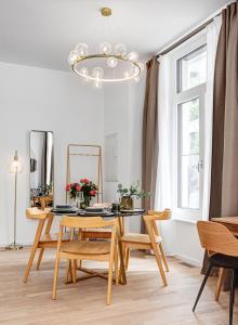 una sala da pranzo con tavolo, sedie e lampadario pendente di Luxury Apartments in East Side Gallery a Berlino